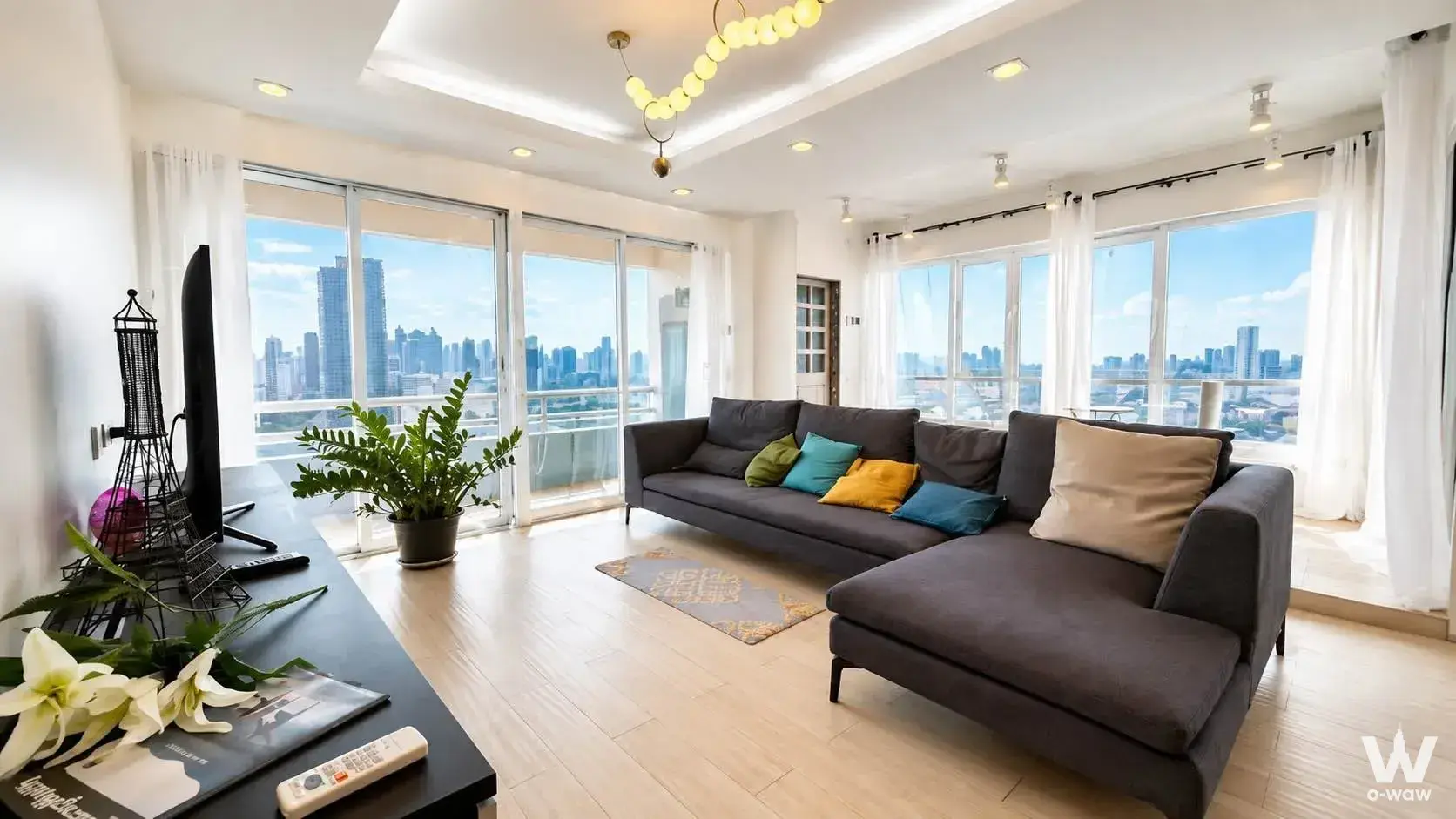 Living room in a 3-bed SRIWARA MANSION 1 condo with a grey sectional sofa and floor-to-ceiling city views