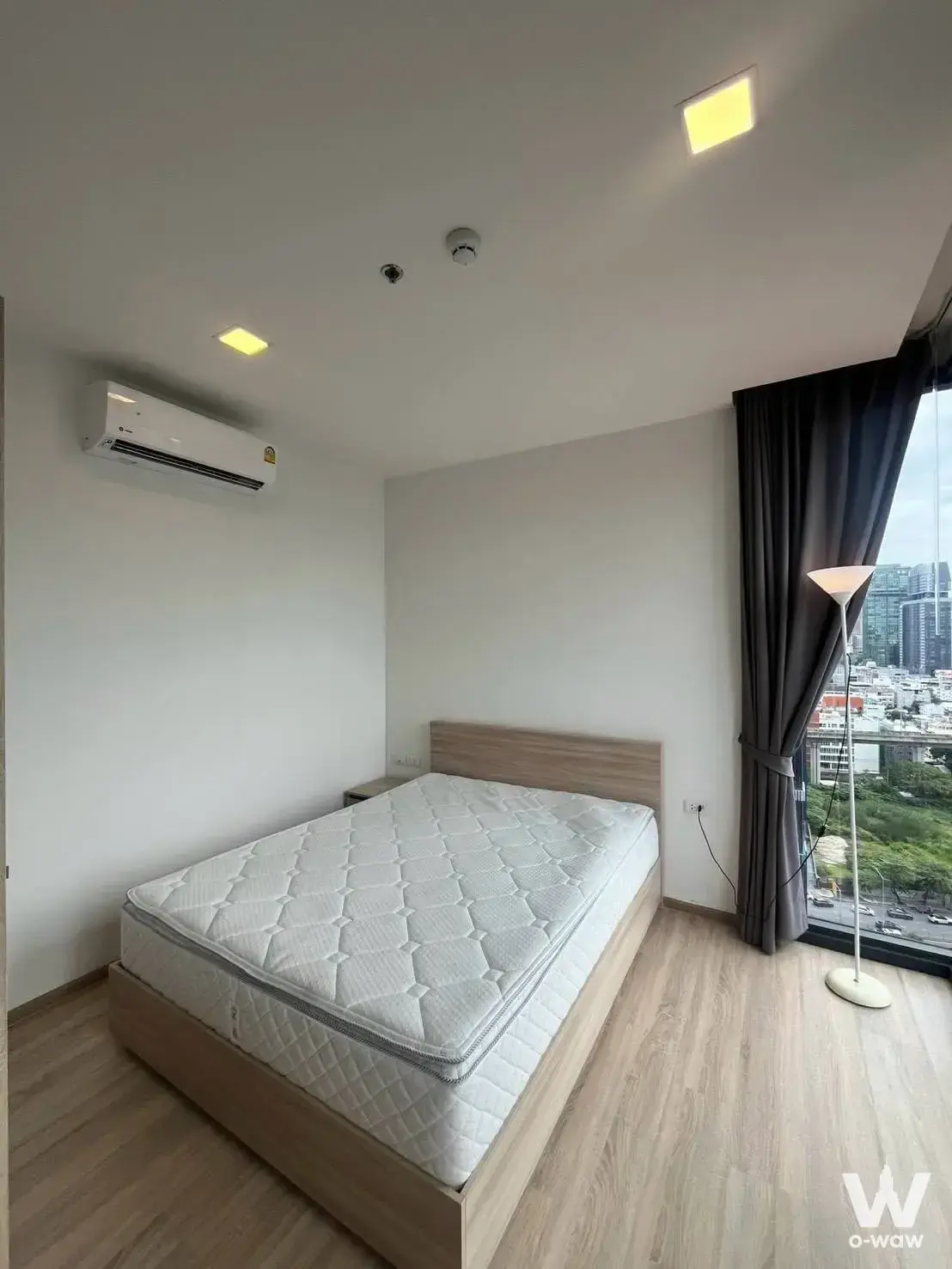 Bedroom in XT Phayathai 1-bed condo with queen bed and floor-to-ceiling window city view
