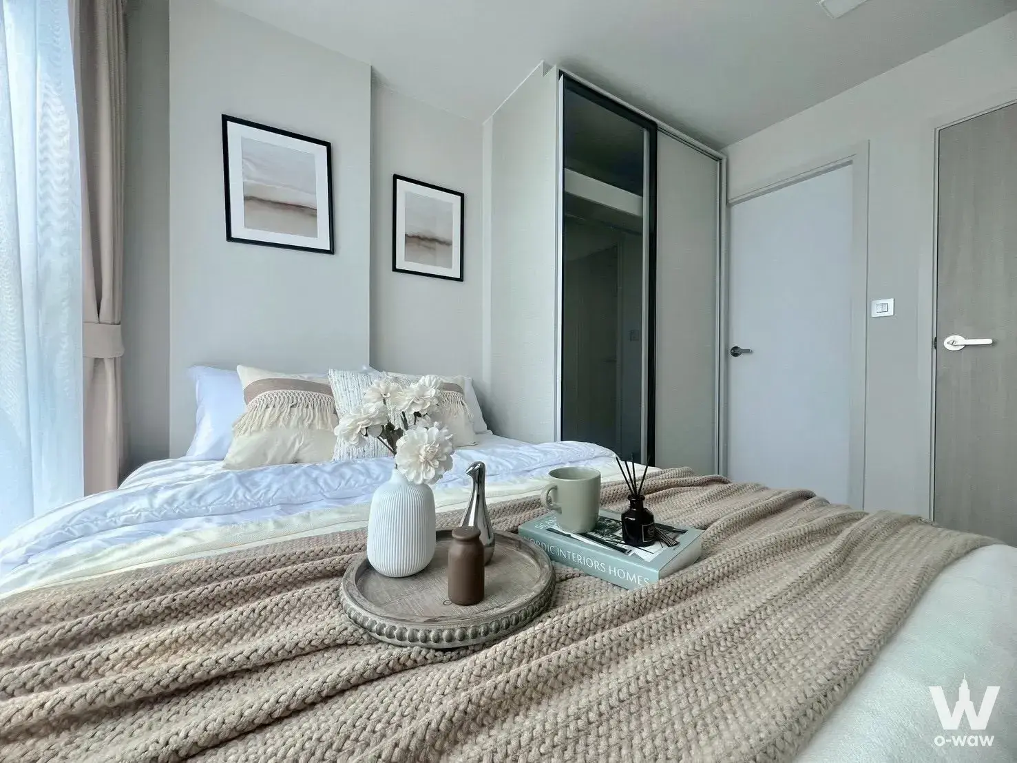 Bedroom in an Atmoz Oasis Onnut condo featuring a queen bed and abstract wall art