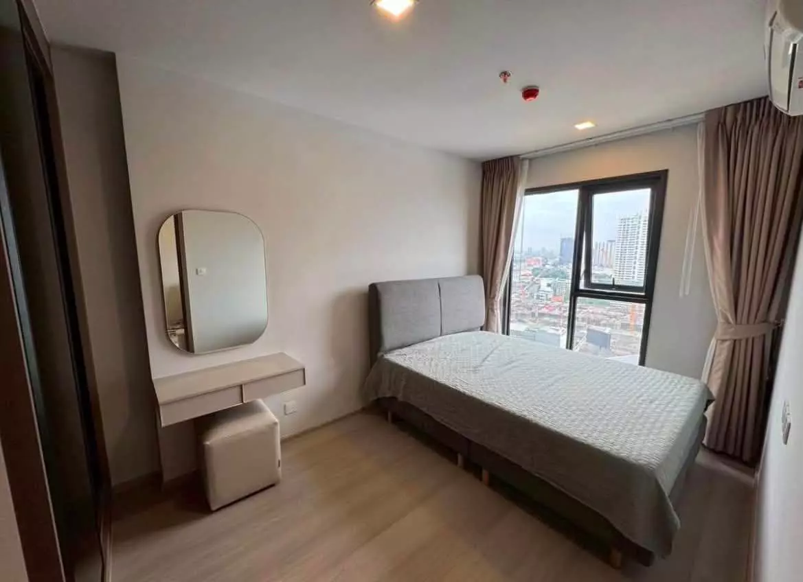 Bedroom in a Life Phahon-Ladprao rental with a floating vanity desk and large window