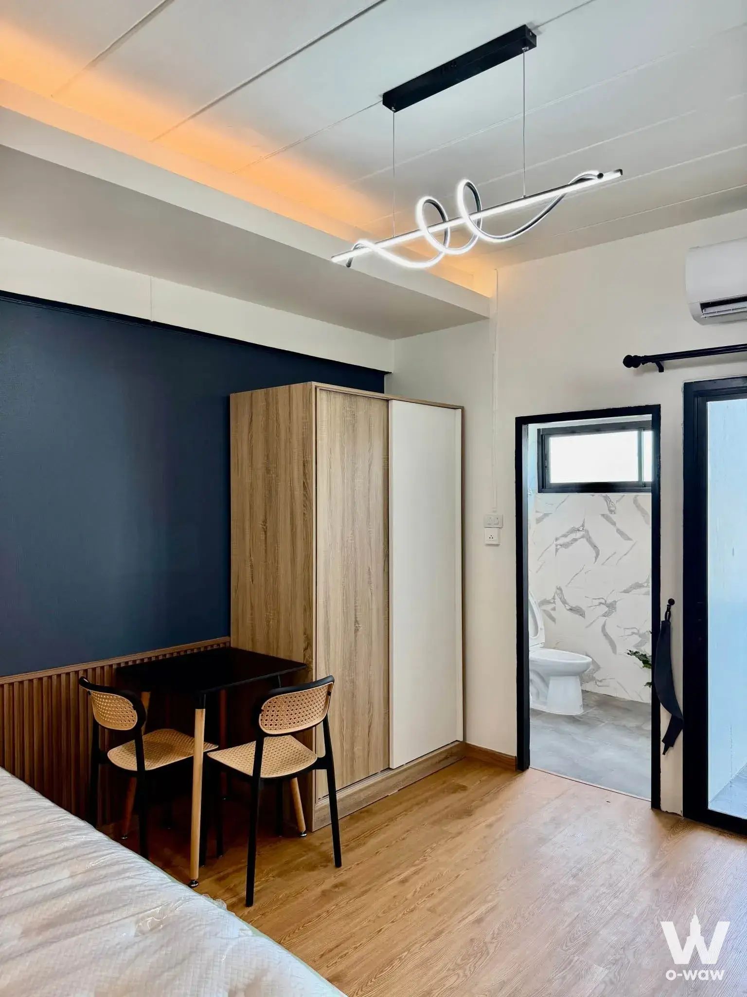 Rom Yen Condominium 1-bed condo bedroom with navy blue accent wall and vertical wood slat wainscoting