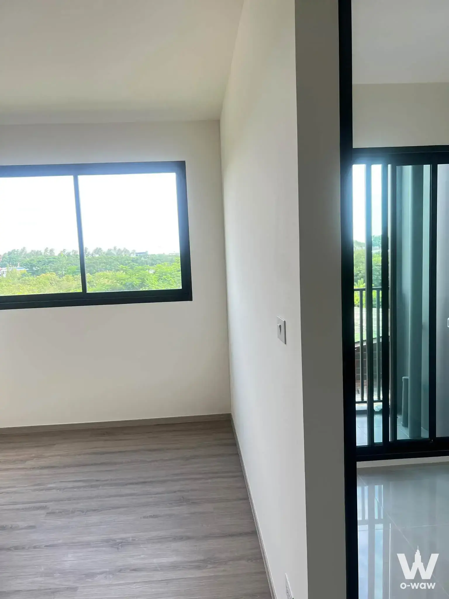 Unfurnished condo room with wood-look flooring and glass partition door in The Origin Bangkae
