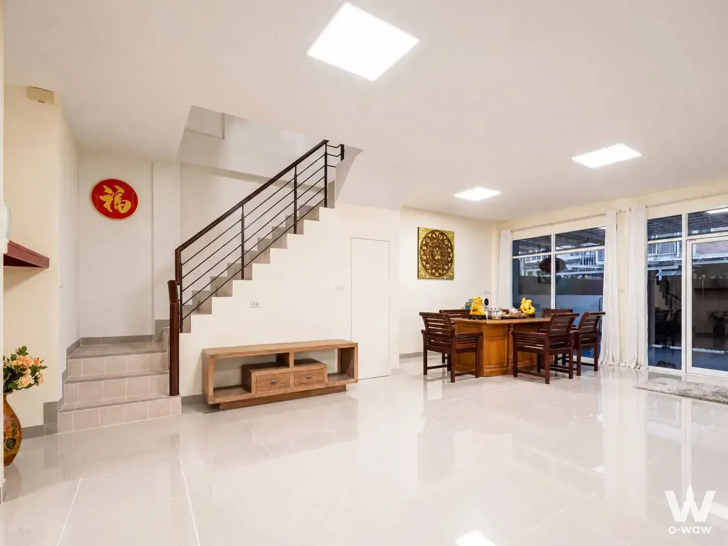 Living-dining area in Baan Bodin condo with gold mandala art and wooden dining table