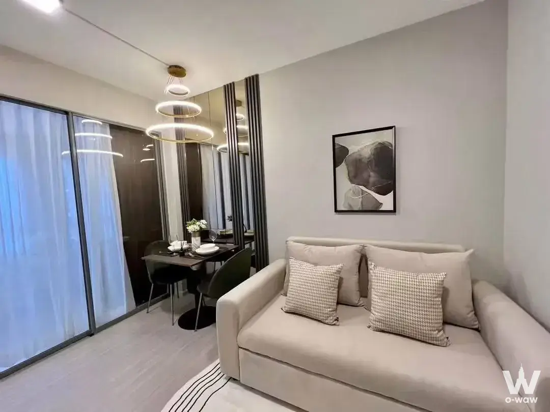 Modern living and dining area with sofa and green chairs in Quintara Phume Sukhumvit 39