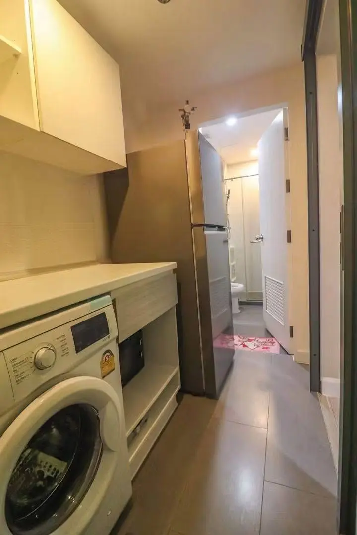 Utility hallway in a 2-bed Metro Sky Prachachuen condo showing a kitchenette, washing machine, and fridge