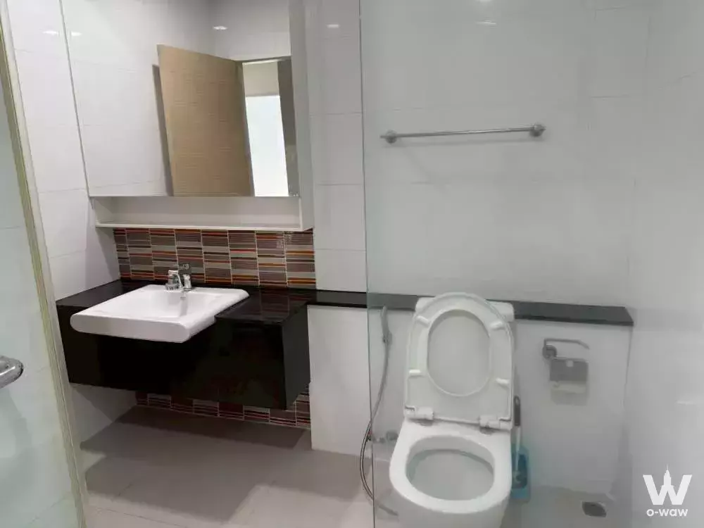 Modern bathroom in a 1-bed condo for sale in The Coast Bangkok featuring a dark floating vanity and striped mosaic tile