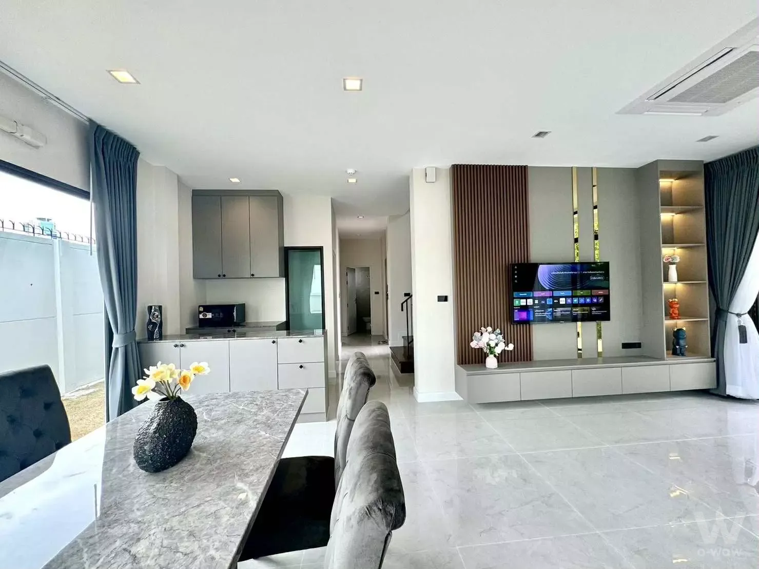 Open-plan living area in a Grand Bangkok Boulevard Sathorn condo with grey marble floors and a stone dining table