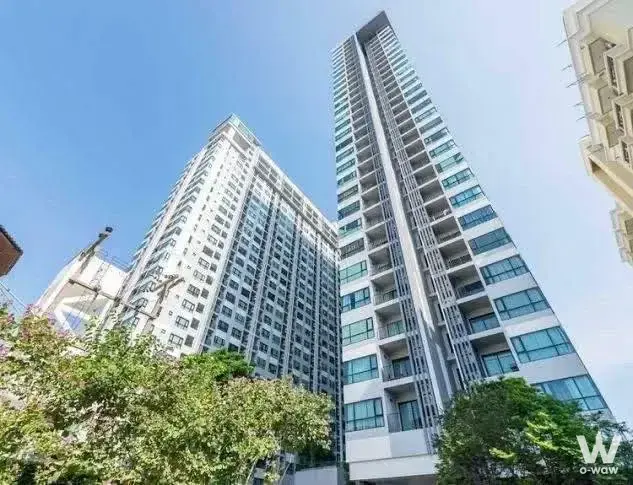 Two modern high-rise condo towers with white and teal accents against a blue sky at The Base Central Pattaya