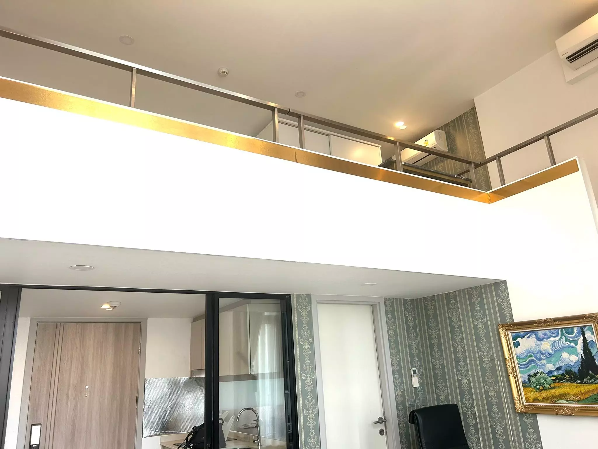 Double-height loft interior with mezzanine and gold accents in a KnightsBridge Prime Sathon 1-bed condo for rent