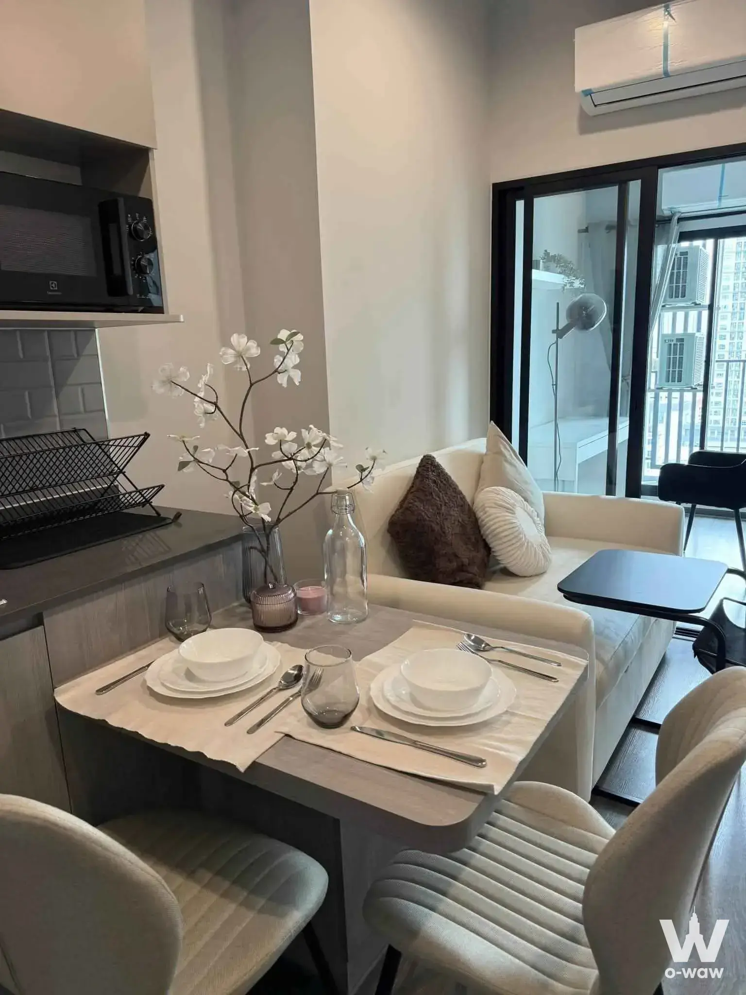 Modern studio in an Ideo Ramkhamhaeng 1-bed condo near Lamsali Station, with neutral tones, balcony access, and minimalist