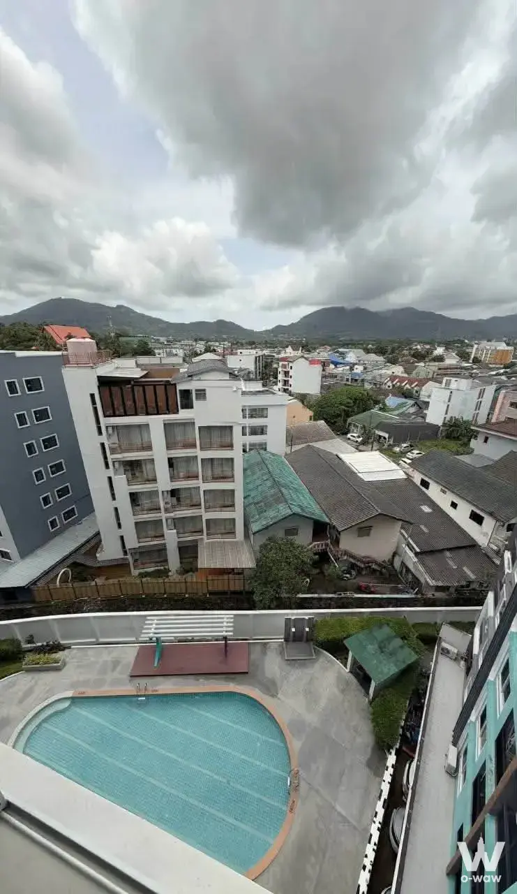 High-floor balcony view of the outdoor pool and urban skyline at The Scene Condo