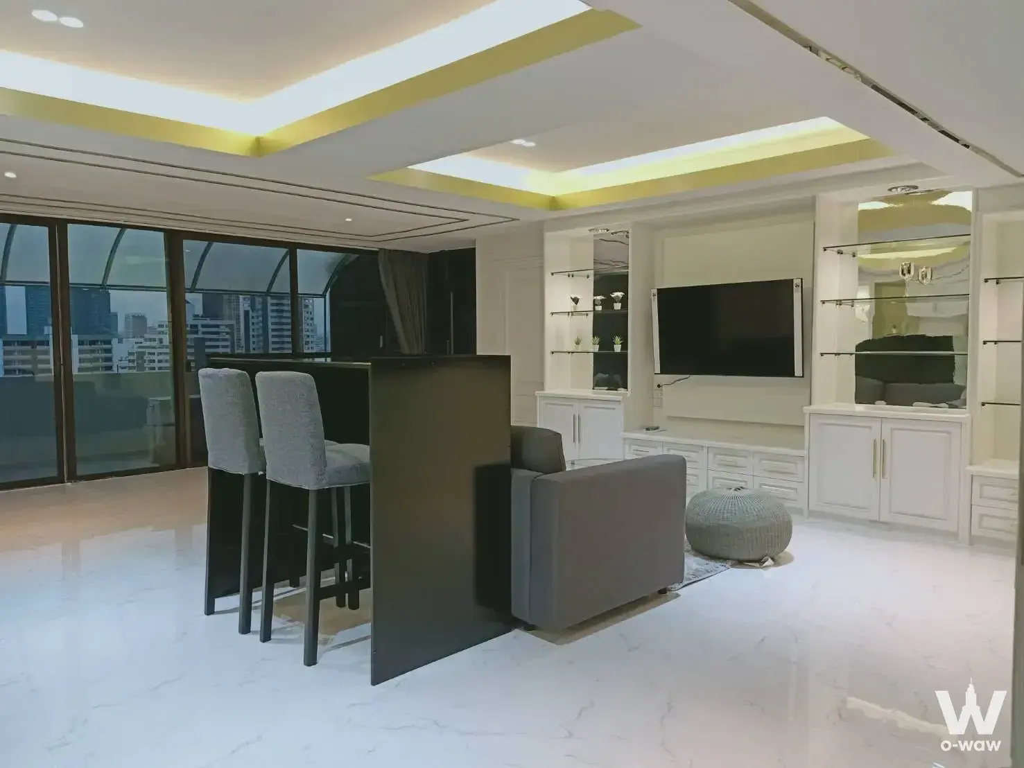 Living room in Waterford Royal Suites condo featuring city skyline view, black bar counter, and glossy floors