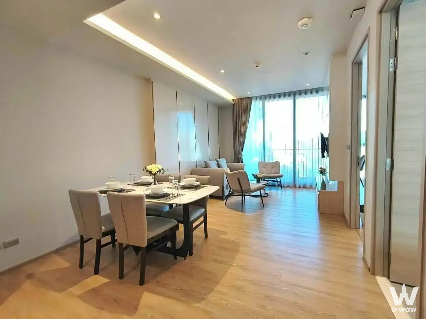 Bearing Residence 1-bed condo for rent features open-plan dining and living area with marble table and city view